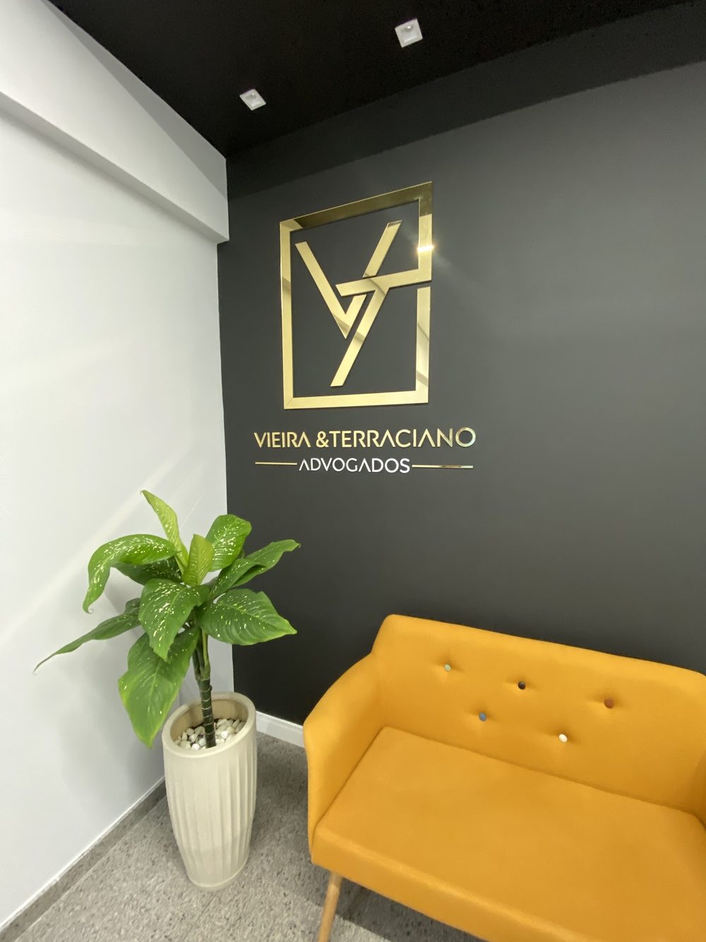Recepção do escritório Vieira e Terraciano, com a logo na parede
